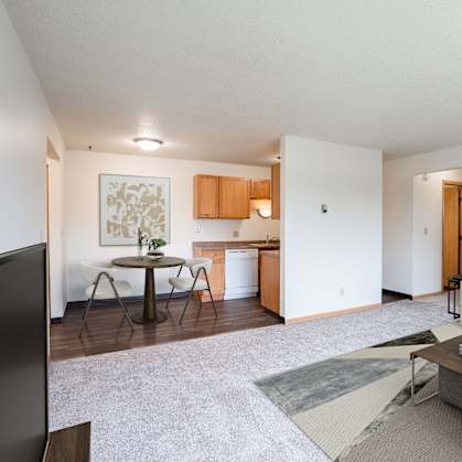 A living room with a couch, coffee table, and television. West Fargo, ND Saddlebrook Apartments