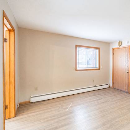 A room with a window and a door. Fargo, ND Birchwood Apartments
