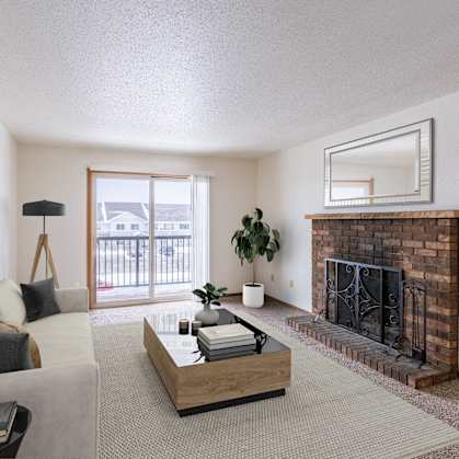 a living room with a fireplace and a couch and a table. Fargo, ND Plumtree Apartments