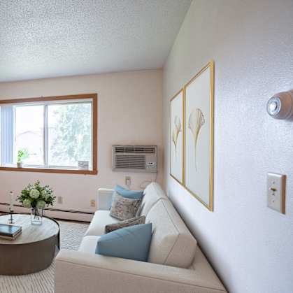 a living room with a couch and a coffee table and a television. Fargo ND Morningside Apartments