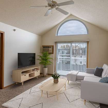 a living room with a couch and a tv and a bedroom. Grand Forks, ND Creekside Apartments.