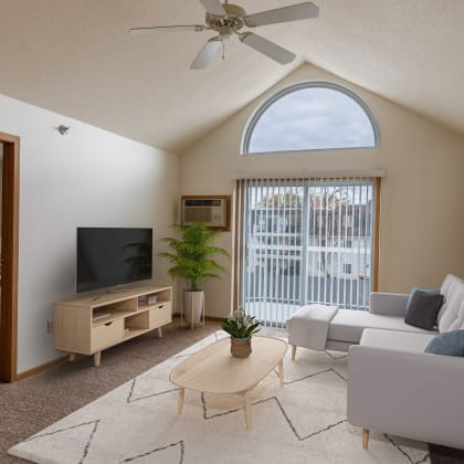a living room with a couch and a tv and a bedroom. Grand Forks, ND Creekside Apartments.