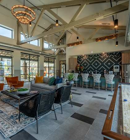 a living room with couches and chairs and a dining room table and a kitchen