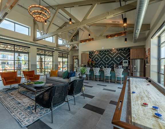 a living room with couches and chairs and a dining room table and a kitchen