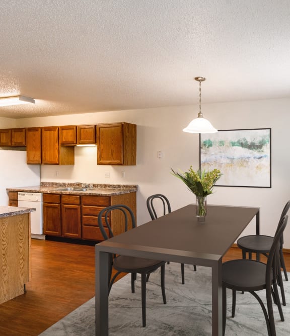 the view of a dining room and kitchen with a table and chairs