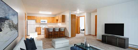 A modern living room with a white couch and a blue coffee table. Fargo, ND Crown Court Apartments