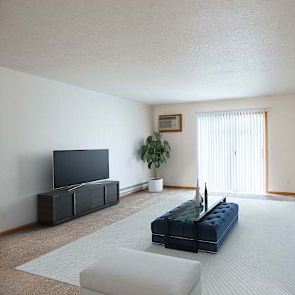 A living room with a blue couch and a television. Fargo, ND Crown Court Apartments