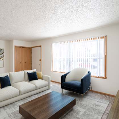 A living room with a white couch and a blue chair. West Fargo, ND Sheyenne Terrace Townhomes