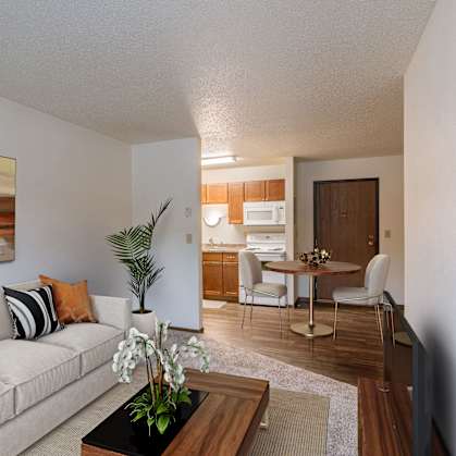 a living room and dining room with a couch and a table. Fargo, ND Parkwood East and West Apartments
