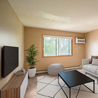 a living room with a white couch and a television. Fargo, ND Brookfield Apartments