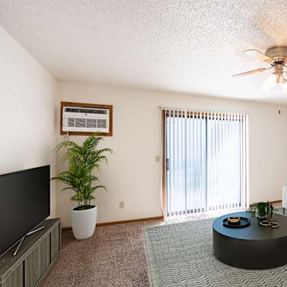 a living room with a couch and a coffee table and a ceiling fan