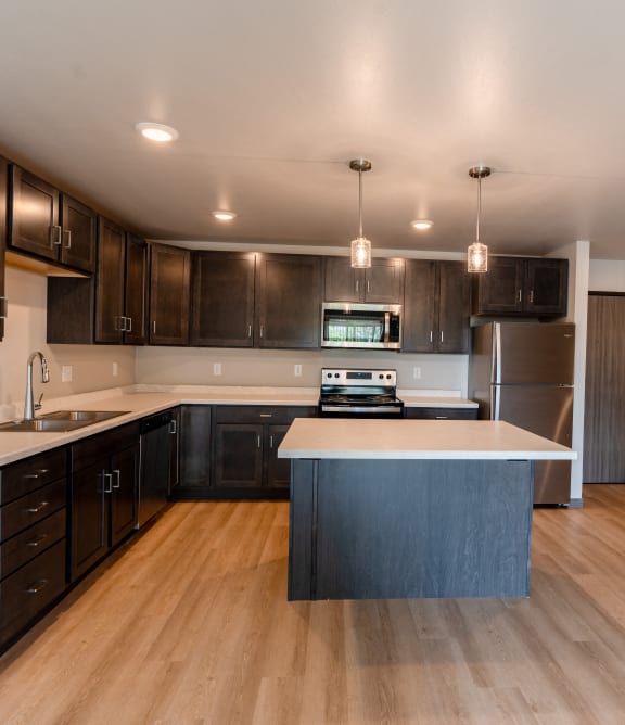 Fargo, ND Granger Court Apartments | Kitchen a kitchen with dark wood cabinets and a white counter top