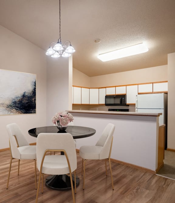 a dining room with a table and chairs and a kitchen