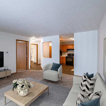 a living room with a couch and a coffee table and a television. Fargo, ND Willow Park Apartments