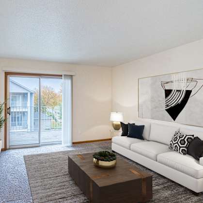 an open living room with a white couch and a tv and a sliding glass door. Fargo, ND Flagstone Apartments