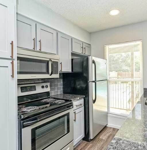 A kitchen with black appliances and white cabinets.