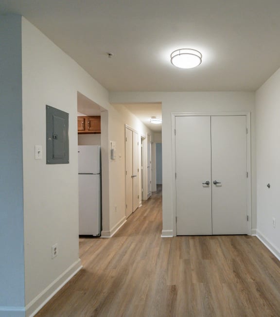 a view of a hallway with white walls and wood floors