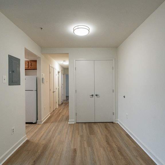 a view of a hallway with white walls and wood floors