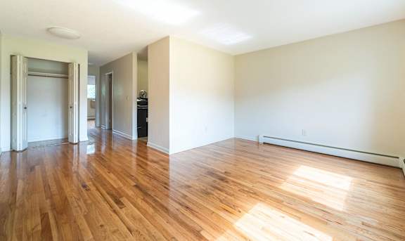 A room with wooden floors and white walls at Coppermine Village Apartment, Bristol, CT, 06010
