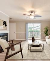 the living room has a fireplace and a ceiling fan