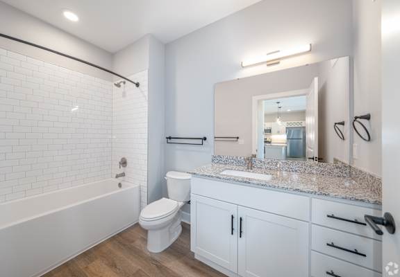 A white bathroom with a toilet, sink, and bathtub.