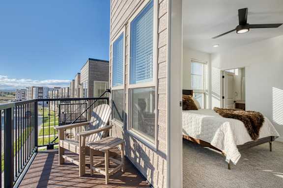 A balcony with a chair and a table is visible.