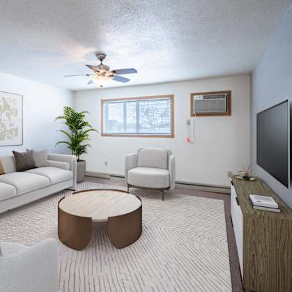 A living room with a white couch, a brown coffee table, and a flat screen TV. Fargo, ND Cedars 4 Apartments