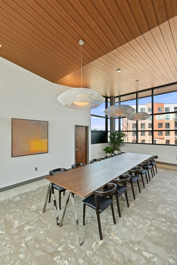A private conference room for Keva Flats residents with a 12-seat table, modern lights, and large windows. at Keva Flats, Pennsylvania, 19341