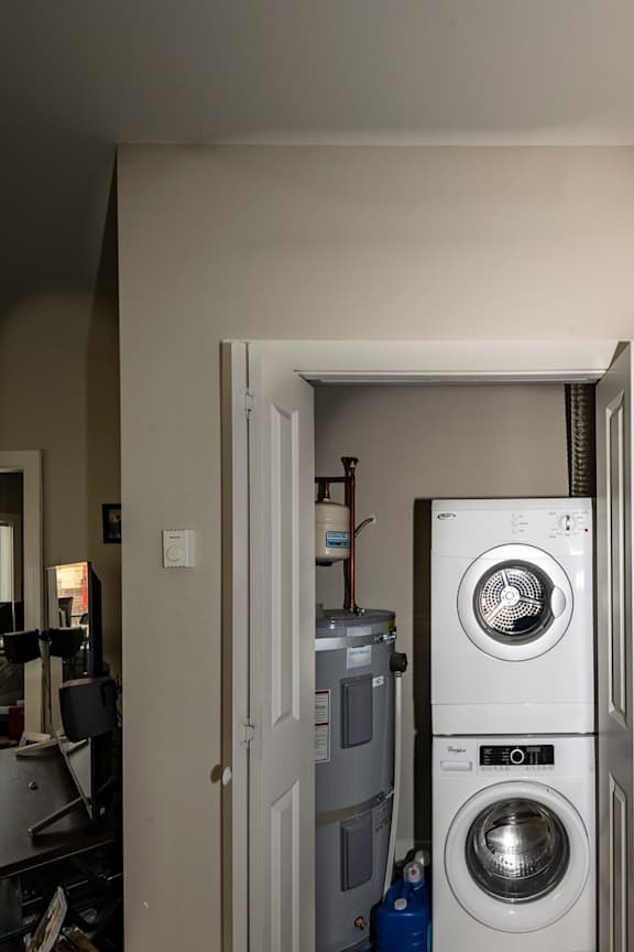 A white door is open to a small laundry room with a washer and dryer.
