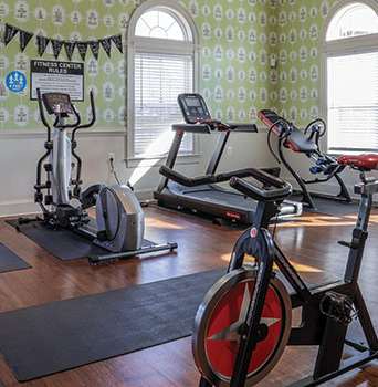 A gym with a row of exercise bikes and a stationary bike in the foreground.