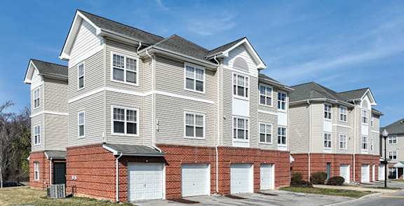 A large, multi-story residential building with a brick base and white upper floors.
