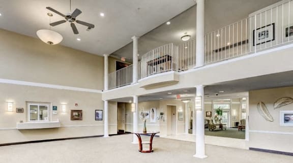 a large lobby with a ceiling fan and a balcony at Windsor Crossing Senior, Maryland, 20746