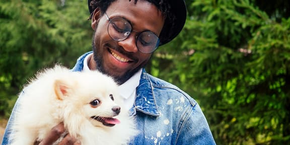a man holding a small white dog  at Two Twelve Clayton, Clayton, MO, 63105