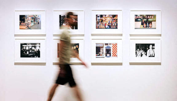 a person walking past pictures on a wall