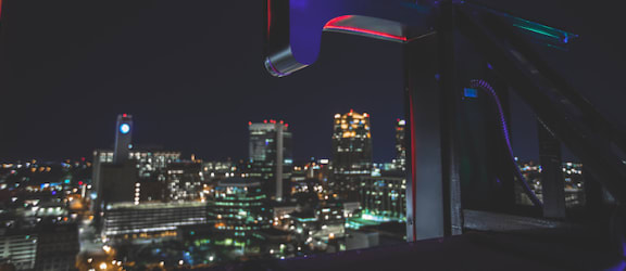 Birmingham skyline illuminated at night from behind the TJ Tower rooftop sign