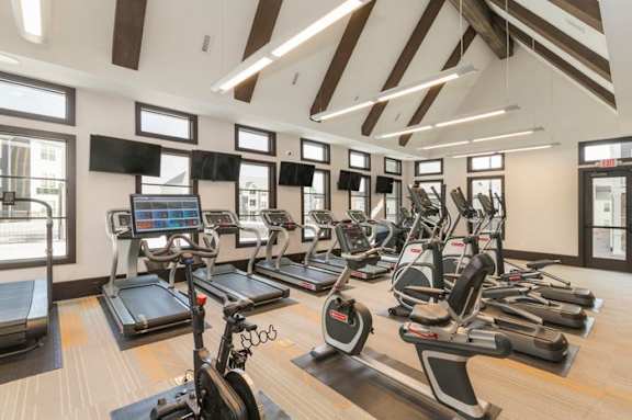 A gym with treadmills, elliptical machines, and other exercise equipment.