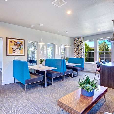 A room with a blue chair and a wooden table.