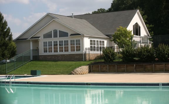 a house with a pool in front of it at St. Charles at Olde Court Apartments, Pikesville, MD