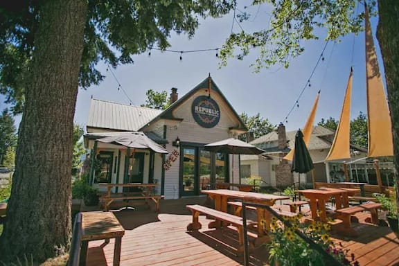 A wooden deck with benches and a building with a sign that says "Republic" in the background.