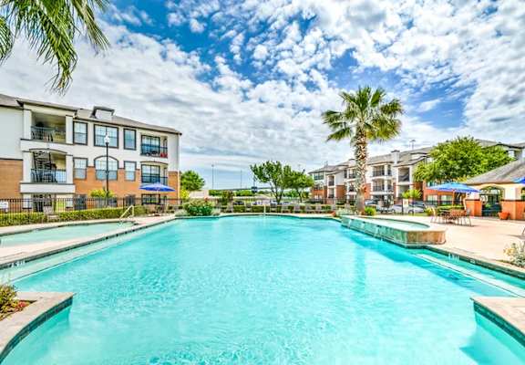 A pool area with chairs and a table.