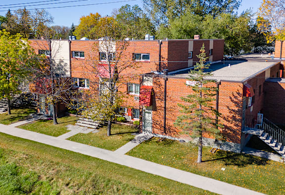A red brick building with a tree in front of it.