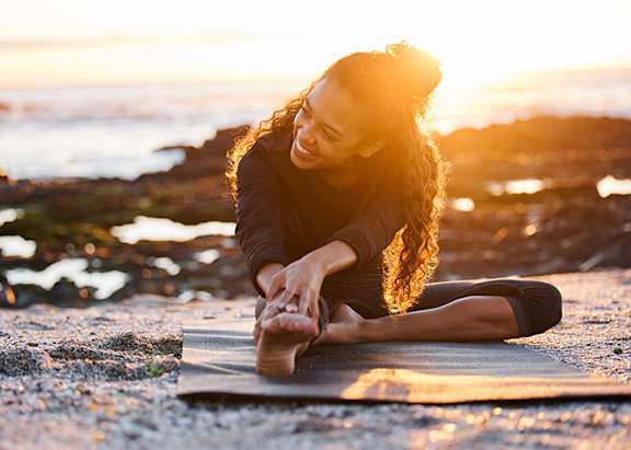 girl on beach doing yoga