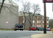 Thumbnail 4 of 5 - a street with cars parked in front of a building