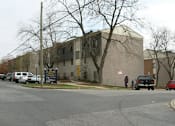 Thumbnail 5 of 5 - a building on the corner of a street with cars parked