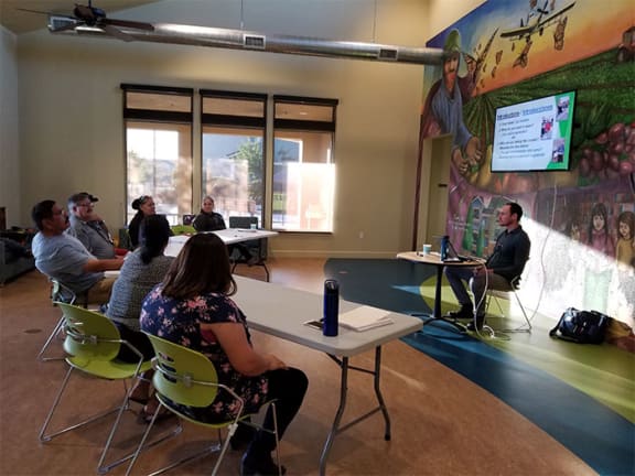 Residents sit and watch a presentation in the Spring Lake community room