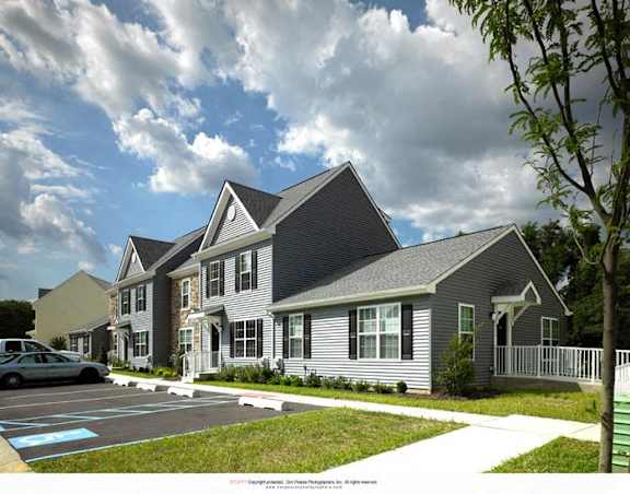 a rendering of a row of houses with cars in a parking lot