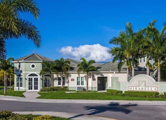 a large house with palm trees in front of it at Mirabella Apartments, Princeton, FL