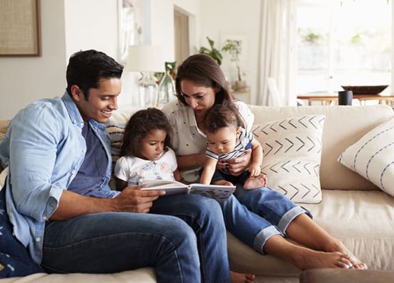 Family looking at book in living room at Harbour Cove, Hallandale Beach, FL 33009