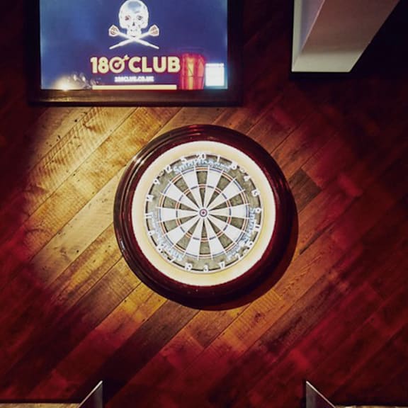 A dartboard is mounted on a wooden wall.