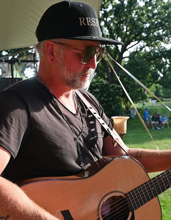 a man with a hat playing a guitar